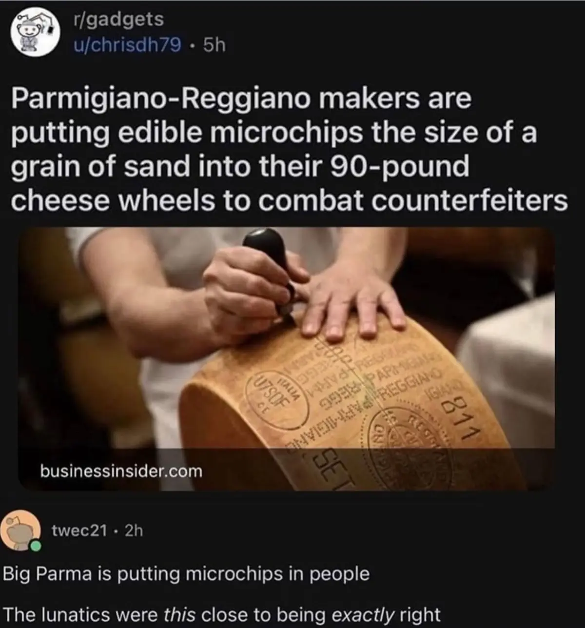 A close-up photo shows a person's hands stamping a large, round, 90-pound Parmigiano-Reggiano cheese wheel with…