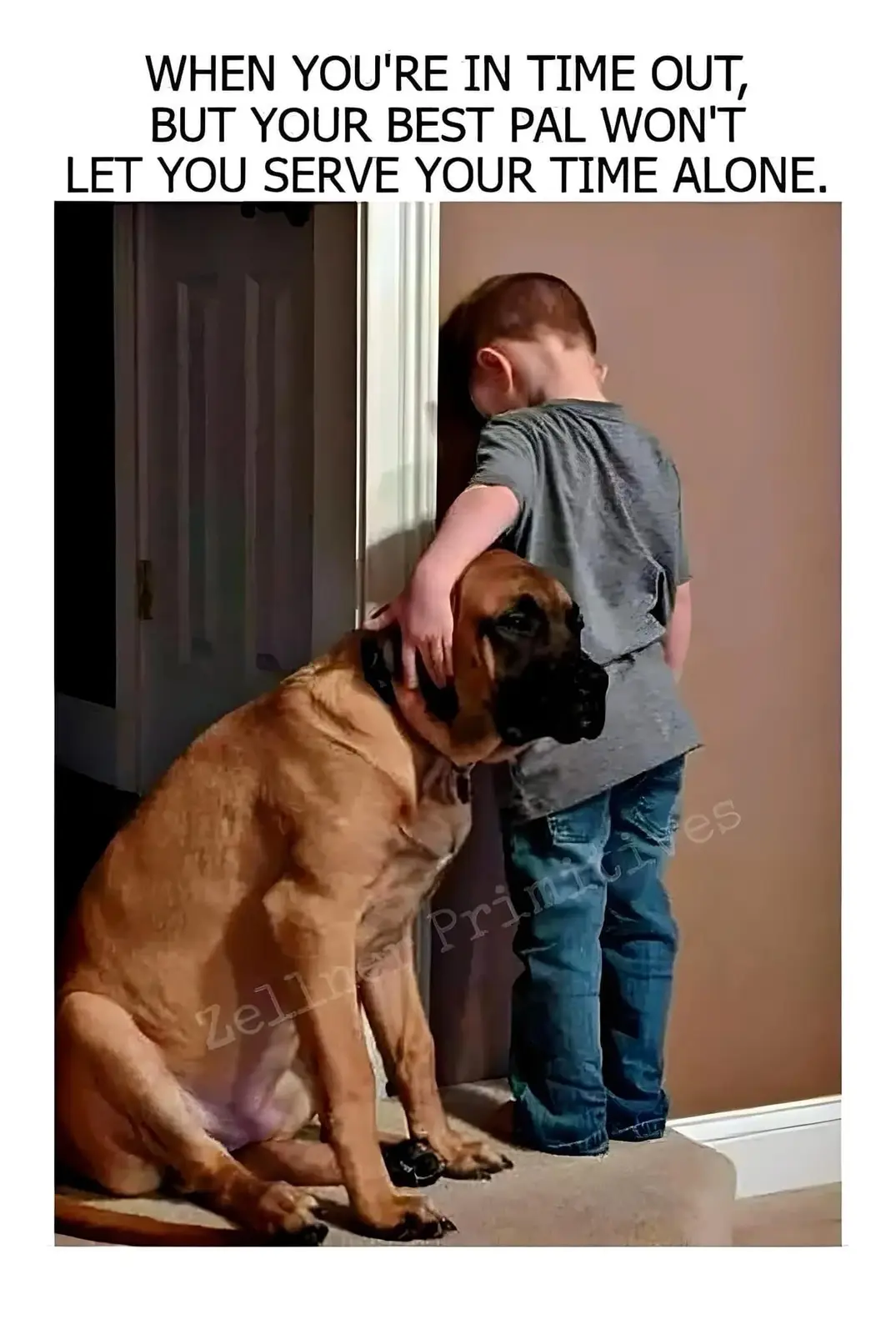 A young child in a grey t-shirt and jeans is standing with their back to the camera, leaning against a wall with their head…