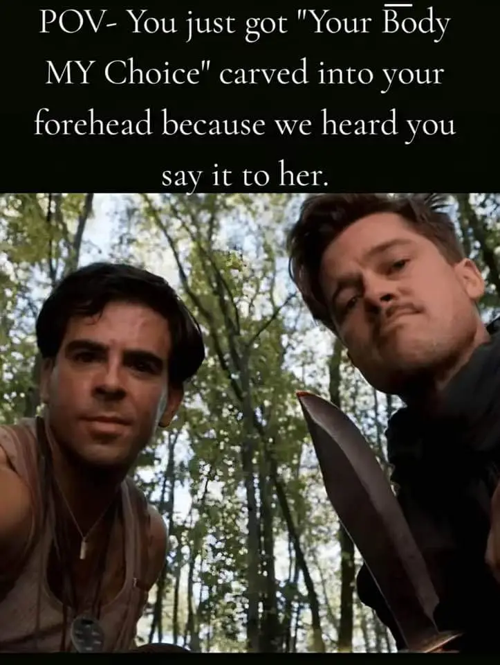 Two men in a forest, one holding a large knife, looking down at the camera with serious expressions. The text overlay reads…