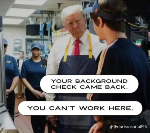 A man with white hair wearing a blue apron and red tie stands in a fast-food kitchen, looking sternly at a young person in a…