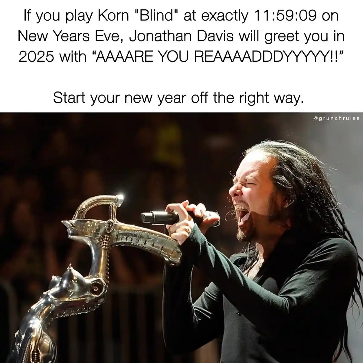 A photo of Korn's Jonathan Davis singing passionately into a microphone while holding a large, ornate, metallic object…