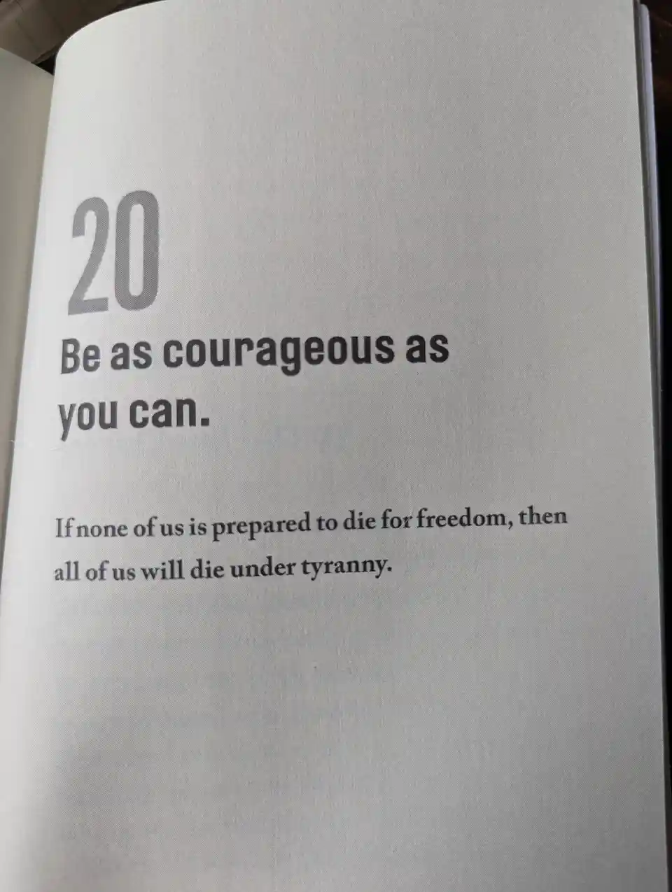 A close-up photo of an open book page showing the number 20, followed by the text 'Be as courageous as you can.' and the…