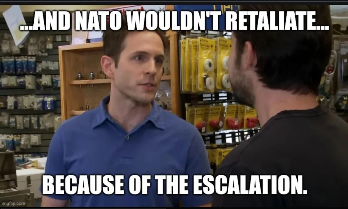 A man in a blue polo shirt stands in a hardware store, looking at another man in a black shirt, with shelves of tools and…
