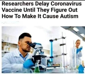 A man in a lab coat and blue gloves peers intently through a microscope in a science lab, with another person in the…