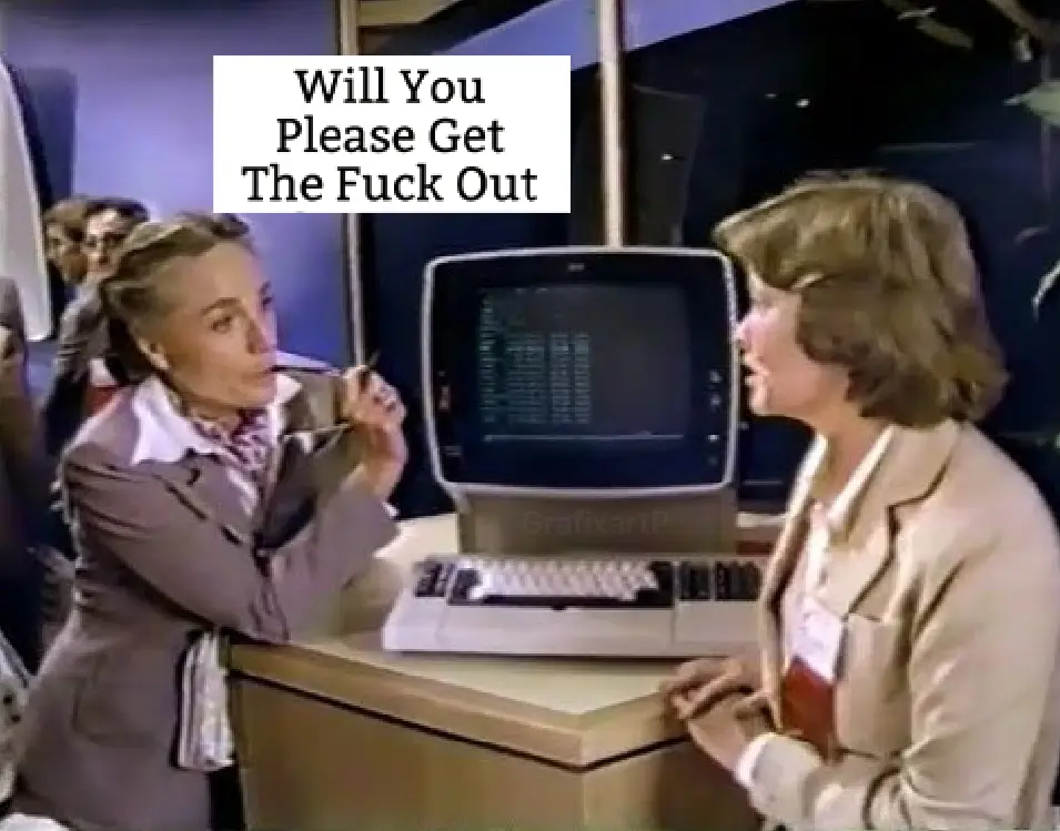 A woman in a beige suit stands at a desk with an old computer, looking annoyed while holding a cigarette to her lips…