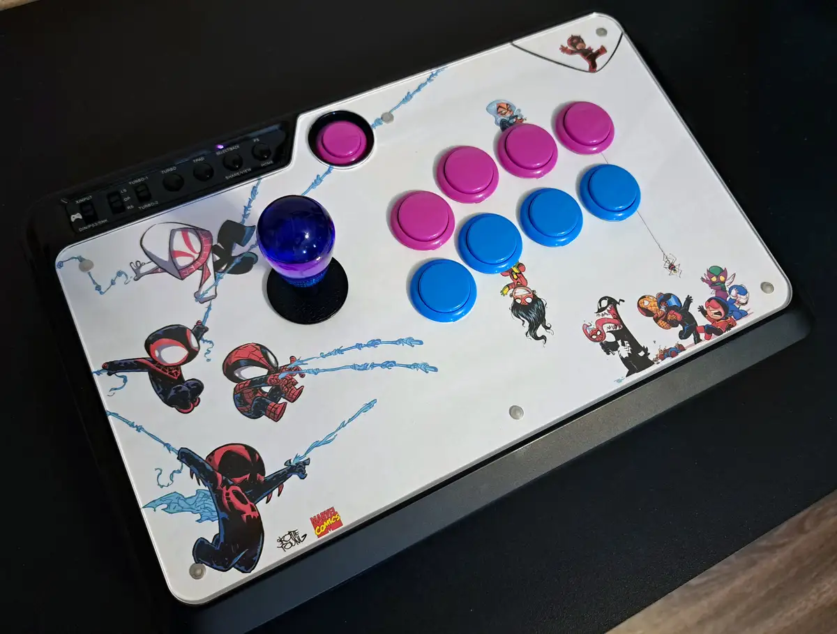 A white arcade fight stick controller decorated with various Spider-Man characters and villains from the Marvel universe…