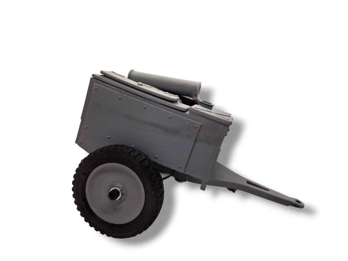 A gray 3D-printed model of a small cannon on a single wheeled cart, set against a plain white background. The overlaid text…