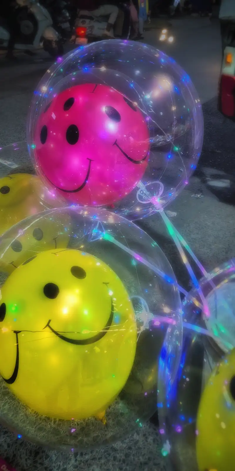 The image shows several large, transparent balloons with colorful LED lights inside, each containing a smaller balloon with…