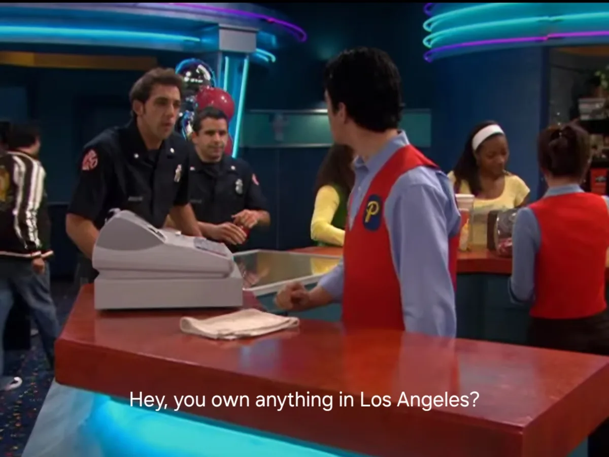A scene from the TV show 'Phineas and Ferb' shows a man in a red vest asking a police officer behind a counter, 'Hey, you…