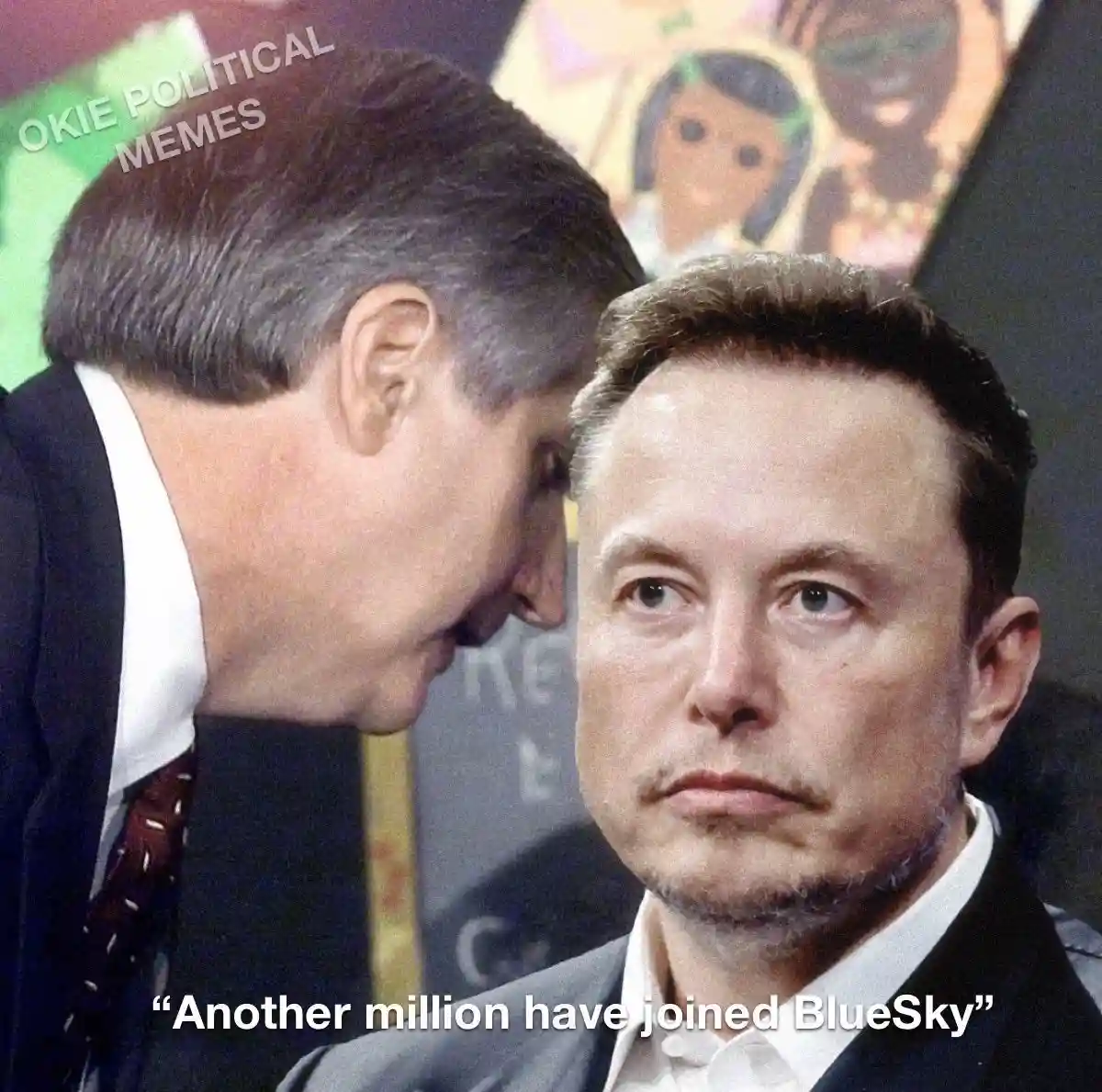 A man in a suit leans in close to Elon Musk, who stares blankly ahead with a bored expression. Text at the bottom reads…