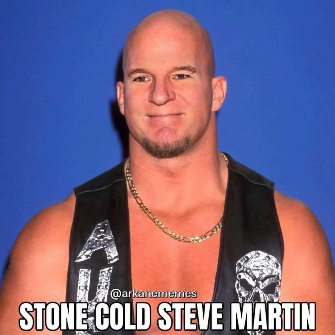 A bald, muscular man with a goatee and a gold chain, wearing a black vest with skull and lettering designs, poses against a…