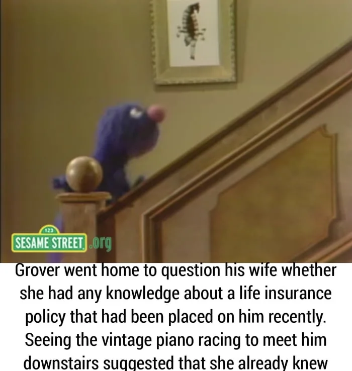 A still from Sesame Street shows Grover, a blue furry Muppet, peeking over a wooden staircase banister. A framed picture…