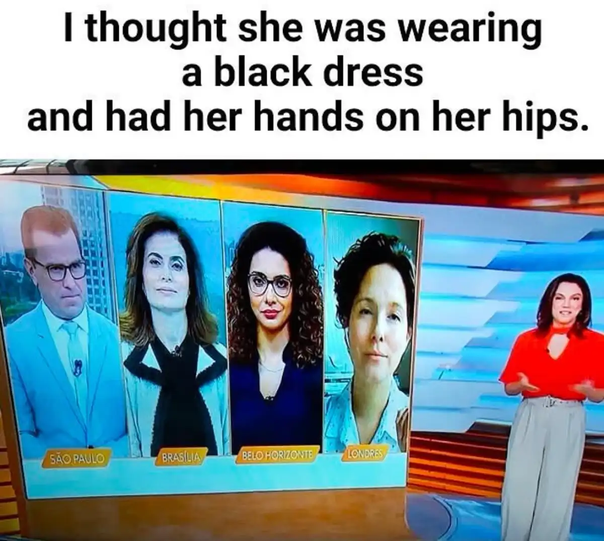 A television news broadcast shows a female anchor in a red top and light pants standing to the right, gesturing. To her…