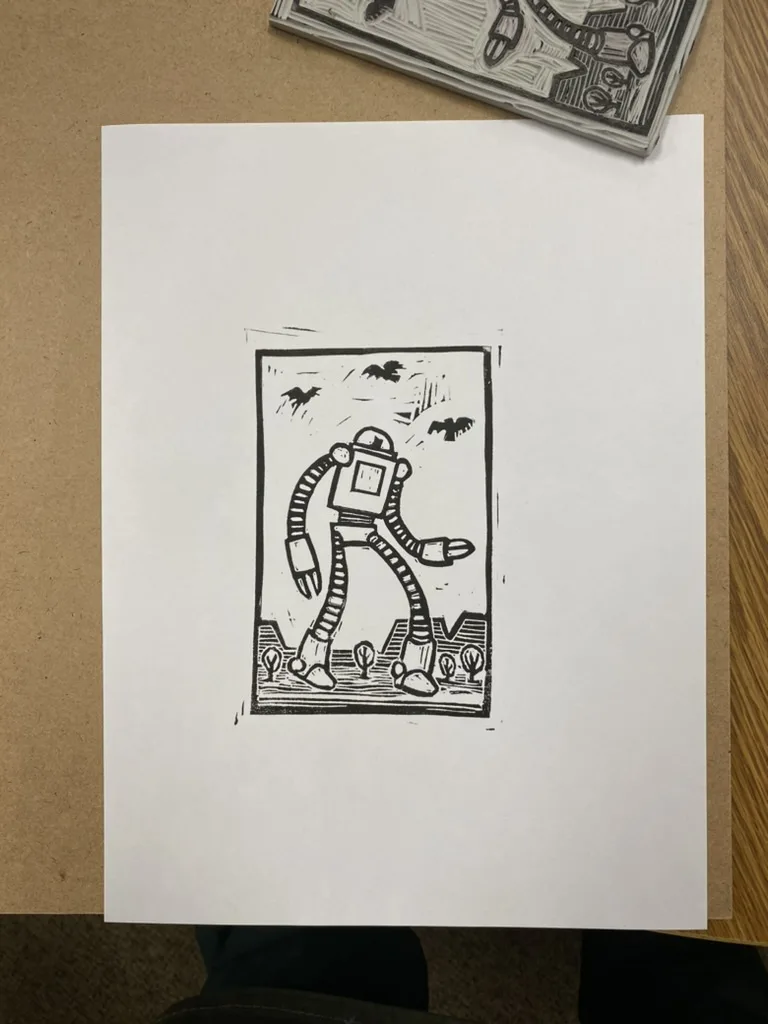 A black-and-white linocut print depicts a stylized robot with segmented arms and legs standing in a barren landscape with…
