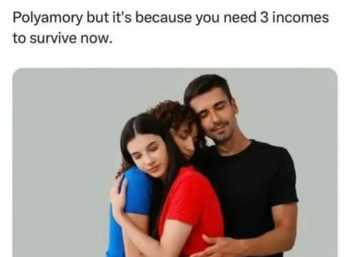 Three people are hugging closely in a group hug against a plain gray background. A man in a black t-shirt stands on the…