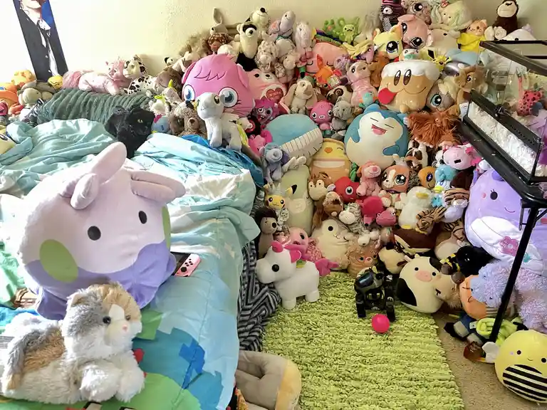 A bedroom is completely overwhelmed by a massive collection of stuffed animals, piled high on the bed, floor, and shelves…