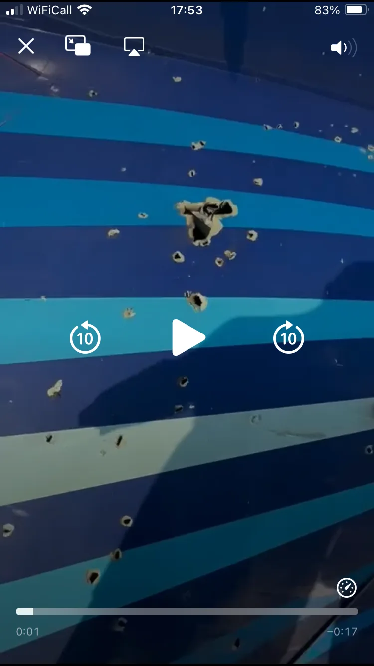 A video player interface overlays a close-up of a blue and teal striped surface riddled with numerous holes, including one…