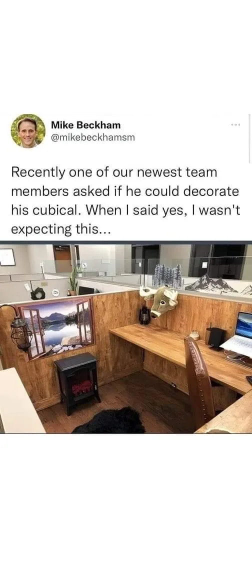 A tweet from Mike Beckham shows a heavily decorated office cubicle featuring a faux wood-paneled wall, a fake fireplace, a…