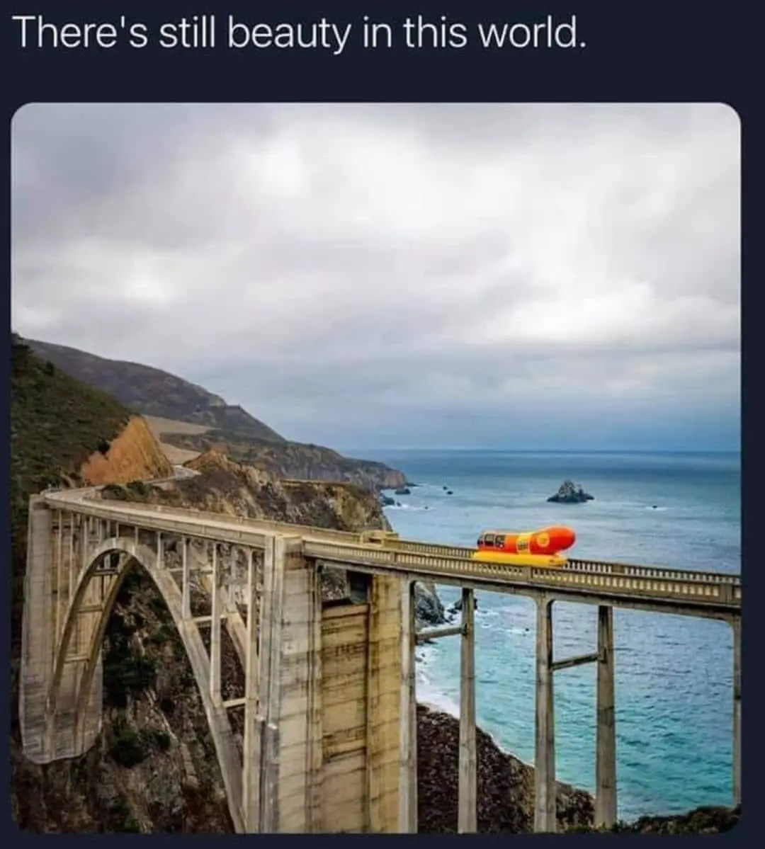 A scenic photo of the Bixby Bridge in California, with a large, bright orange and yellow hot dog-shaped vehicle humorously…
