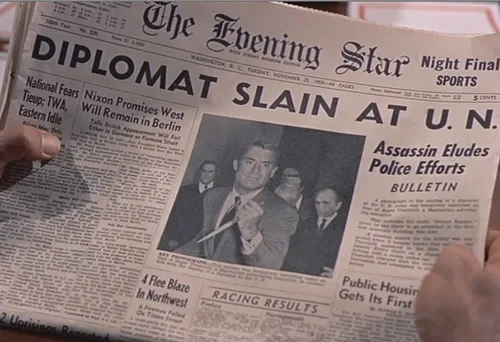A person holds up a vintage newspaper titled 'The Evening Star' with the headline 'DIPLOMAT SLAIN AT U.N.' in large bold…