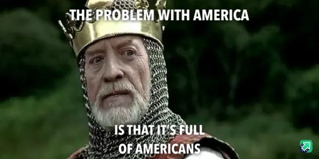 A close-up of an older man with a white beard wearing a gold crown and chainmail, looking directly at the camera with a…