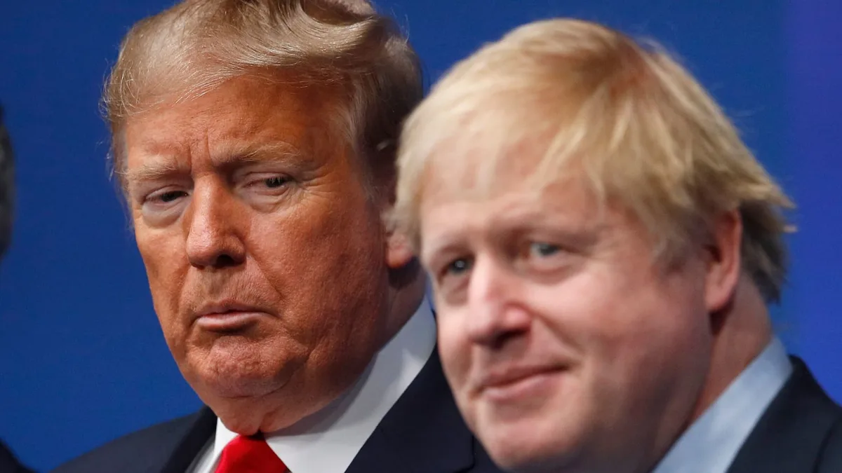 A close-up photo shows Donald Trump looking stern and unimpressed while Boris Johnson smiles beside him. The overlaid text…