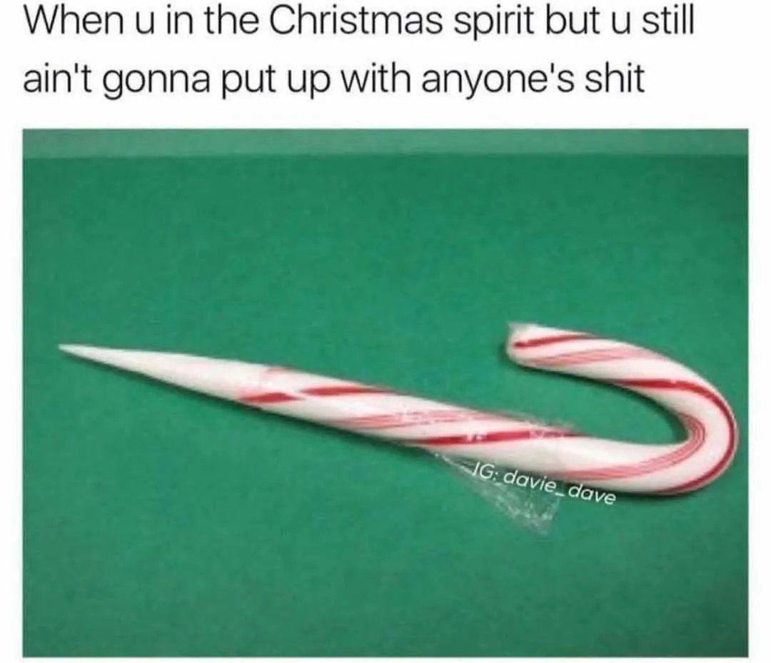 A candy cane with its tip sharpened into a point lies on a green surface. The overlaid text reads 'When u in the Christmas…