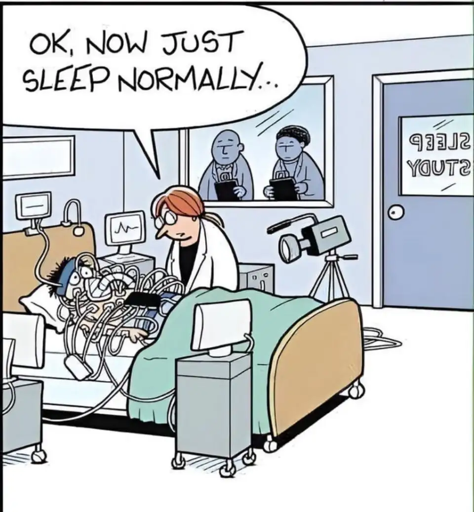 A cartoon depicts a sleep study room where a patient is heavily wired and hooked up to medical equipment in a hospital bed…