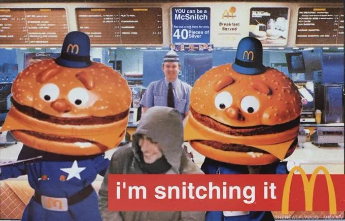 Two large, cartoonish McDonald's mascot characters resembling hamburgers in blue uniforms flank a person in a grey hoodie…