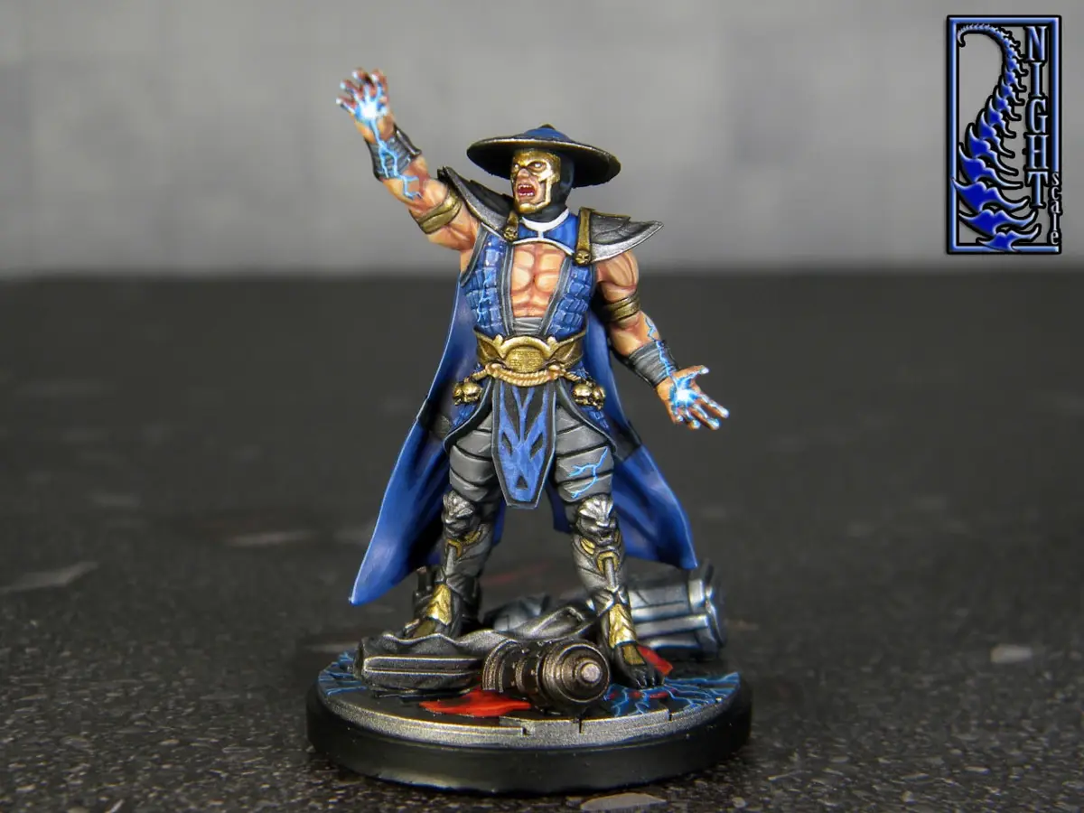 A painted miniature figure of the video game character Scorpion from Mortal Kombat, posed with glowing blue energy in his…