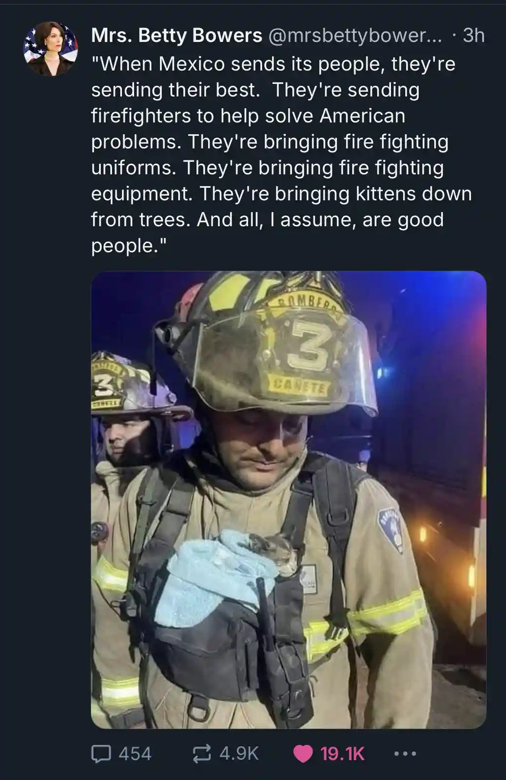 A firefighter wearing a helmet labeled 'BOMBEROS 3 CANETE' holds a small kitten wrapped in a blue cloth against his chest…