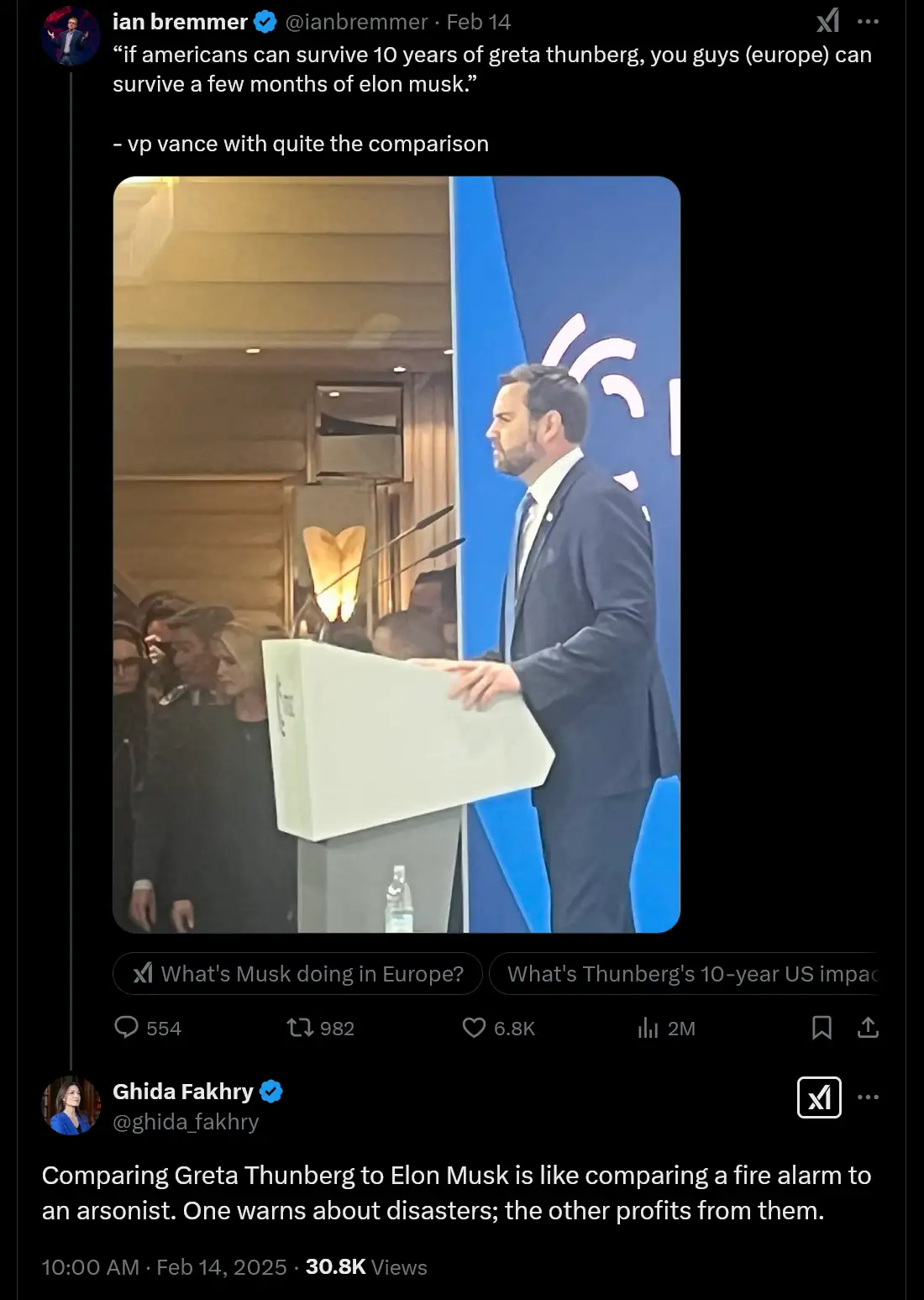 A man in a dark suit stands at a white podium speaking into microphones, with a blue backdrop behind him. The overlaid text…