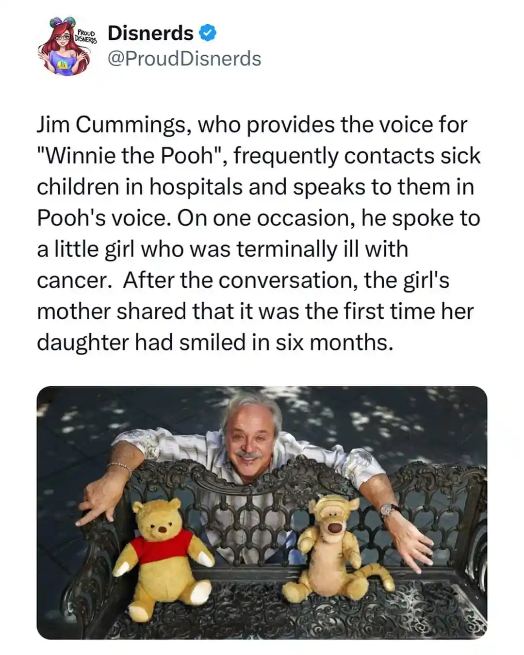 A photo shows actor Jim Cummings sitting on an ornate bench outdoors, smiling at the camera. Two plush toys, Winnie the Pooh…