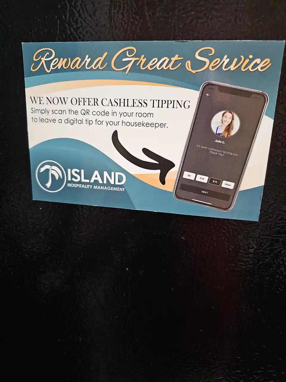 A promotional card from Island Hospitality Management advertises cashless tipping for housekeepers, showing a smartphone…