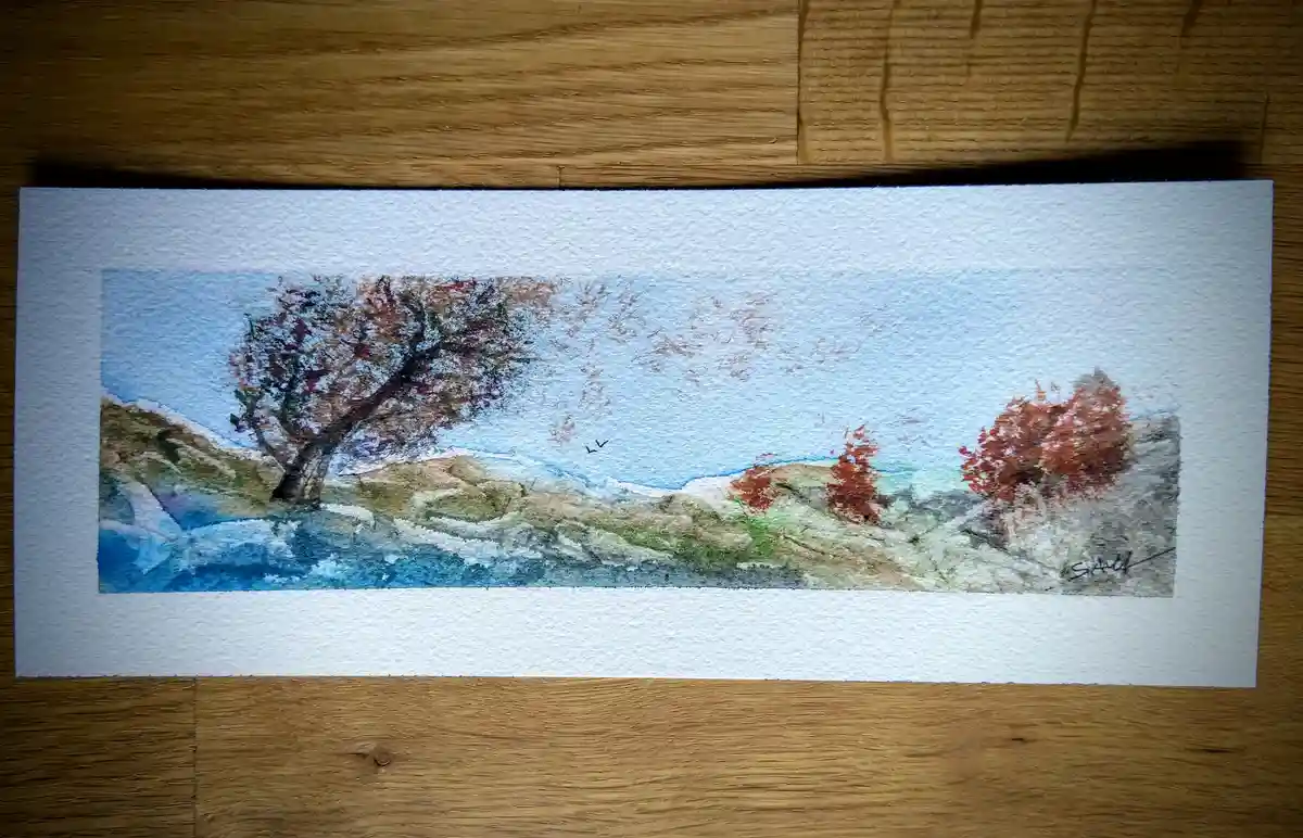 A watercolor painting on textured paper depicts a serene landscape with autumnal trees, rolling hills, and a blue sky with…