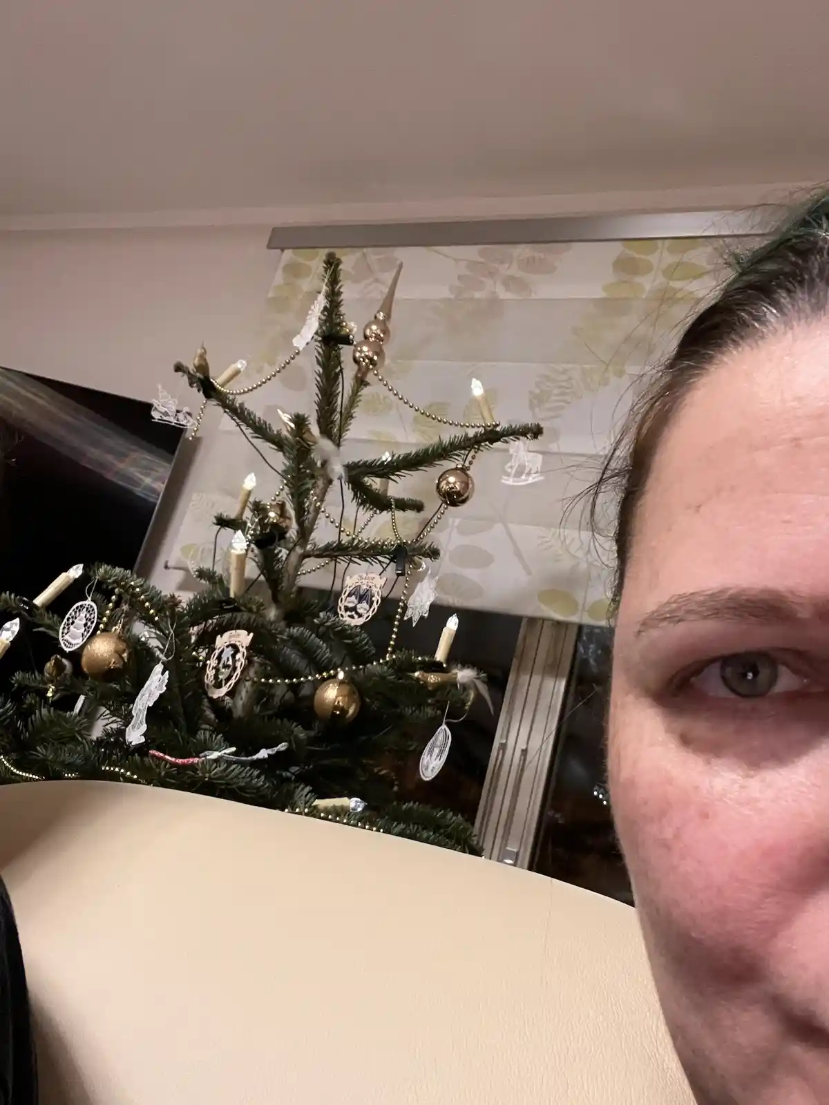 A close-up selfie shows a person's eye and part of their face on the right, looking at the camera, with a small, decorated…
