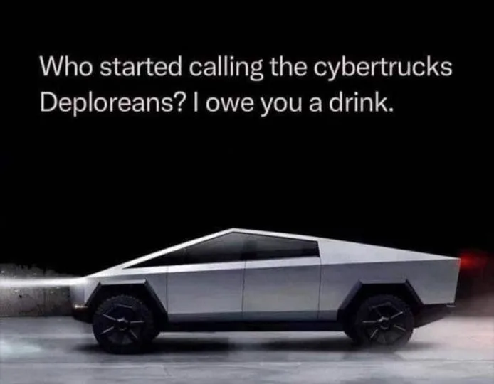 A silver, angular Tesla Cybertruck is shown in profile against a dark background, with its front headlight glowing. White…