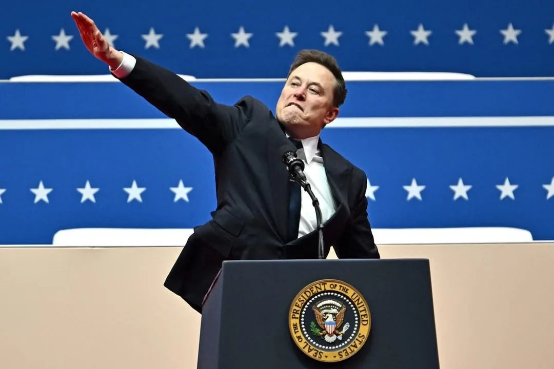a man in a black suit stands at a podium bearing the official seal of the president of the united states, gesturing with his…