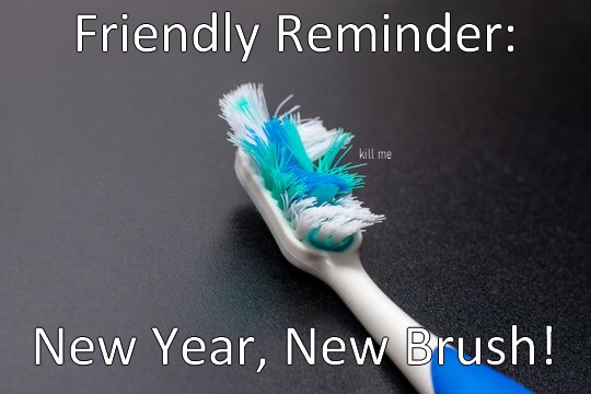 A close-up photo of a severely worn toothbrush with frayed, blue and white bristles lying on a dark gray surface. The text…