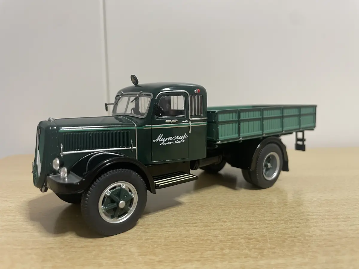 A detailed green die-cast model of a vintage Marazzato truck, featuring 'Marazzato Ivrea-Aosta' lettering on its side, sits…