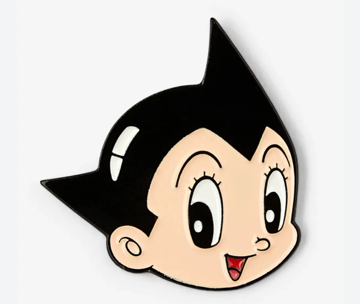 A close-up of a glossy enamel pin featuring the cartoon character Astro Boy, recognizable by his iconic spiky black hair…