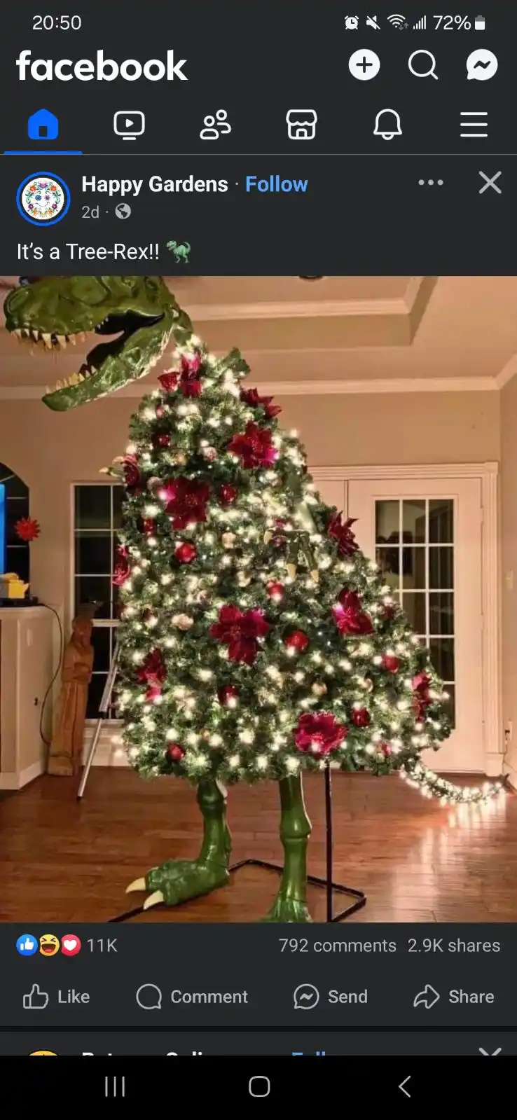 A decorated christmas tree is shaped like a t-rex dinosaur, with the tree forming the body and head, and a green dinosaur…