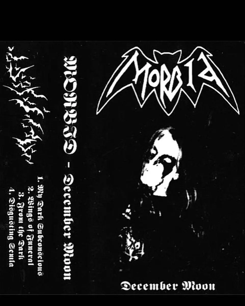 A black-and-white cassette cover for the band Morbia's album 'December Moon', featuring a stylized bat-wing logo, a ghostly…