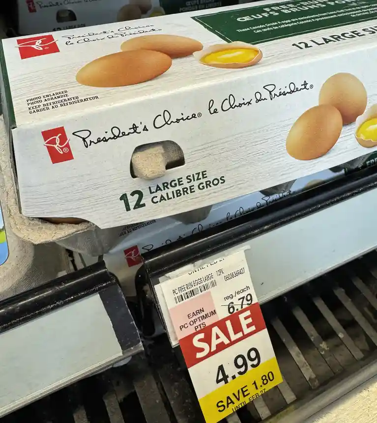 A close-up photo of a 'President's Choice' brand egg carton on a grocery store shelf, with a price tag showing a sale price…