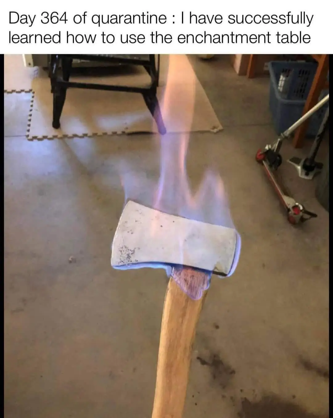 A close-up photo shows an axe head on a wooden handle engulfed in blue and orange flames, set against a concrete floor with…