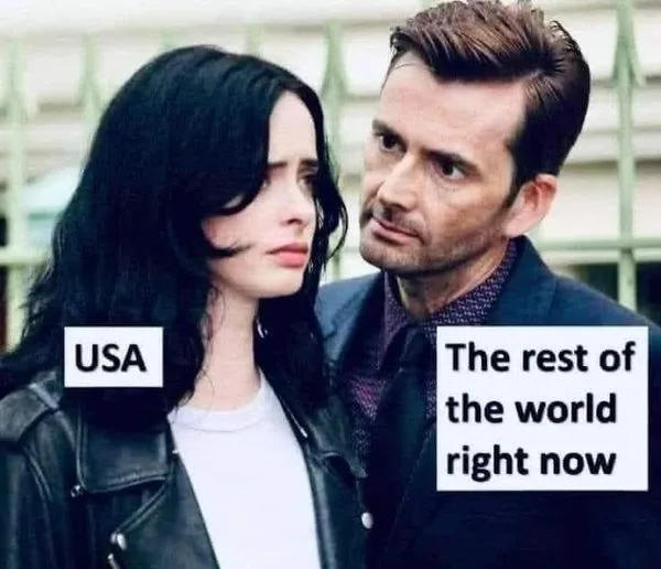 A woman labeled 'USA' looks annoyed and unimpressed while a man labeled 'The rest of the world right now' looks at her with…