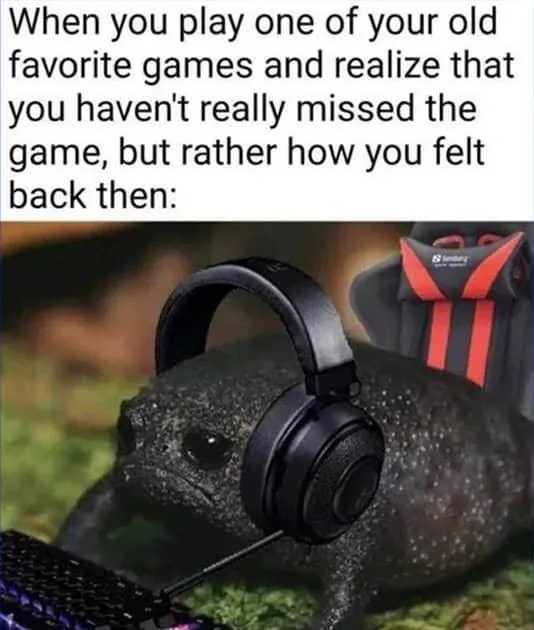 A dark, textured frog sits in front of a keyboard, wearing large black over-ear headphones, with a red and black gaming…