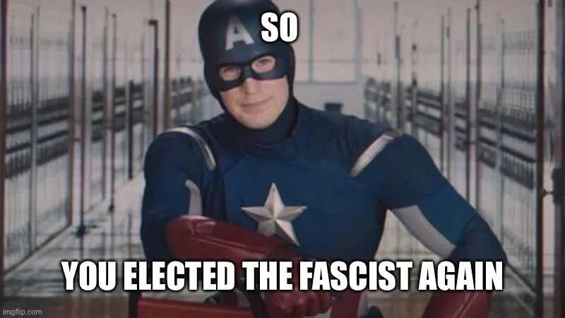 A man in a blue superhero costume with a star on his chest and a helmet with an 'A' stands in a prison corridor. White text…