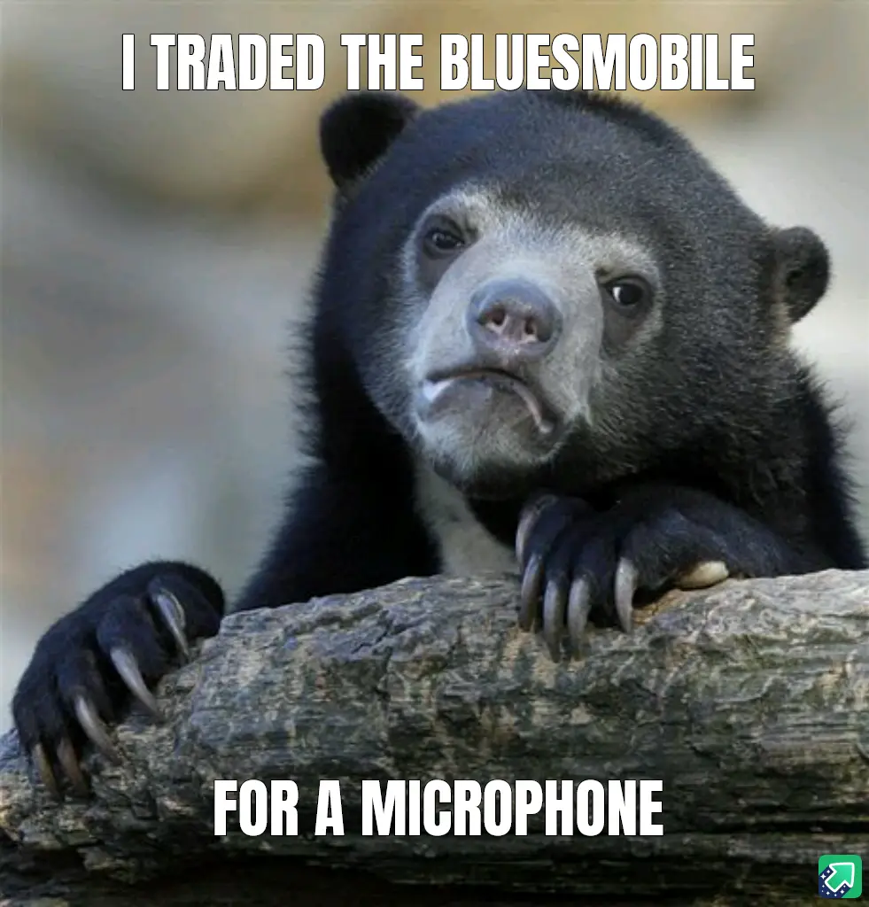 A close-up photo of a sad-looking spectacled bear resting its paws on a log, with white bold text overlaid at the top…