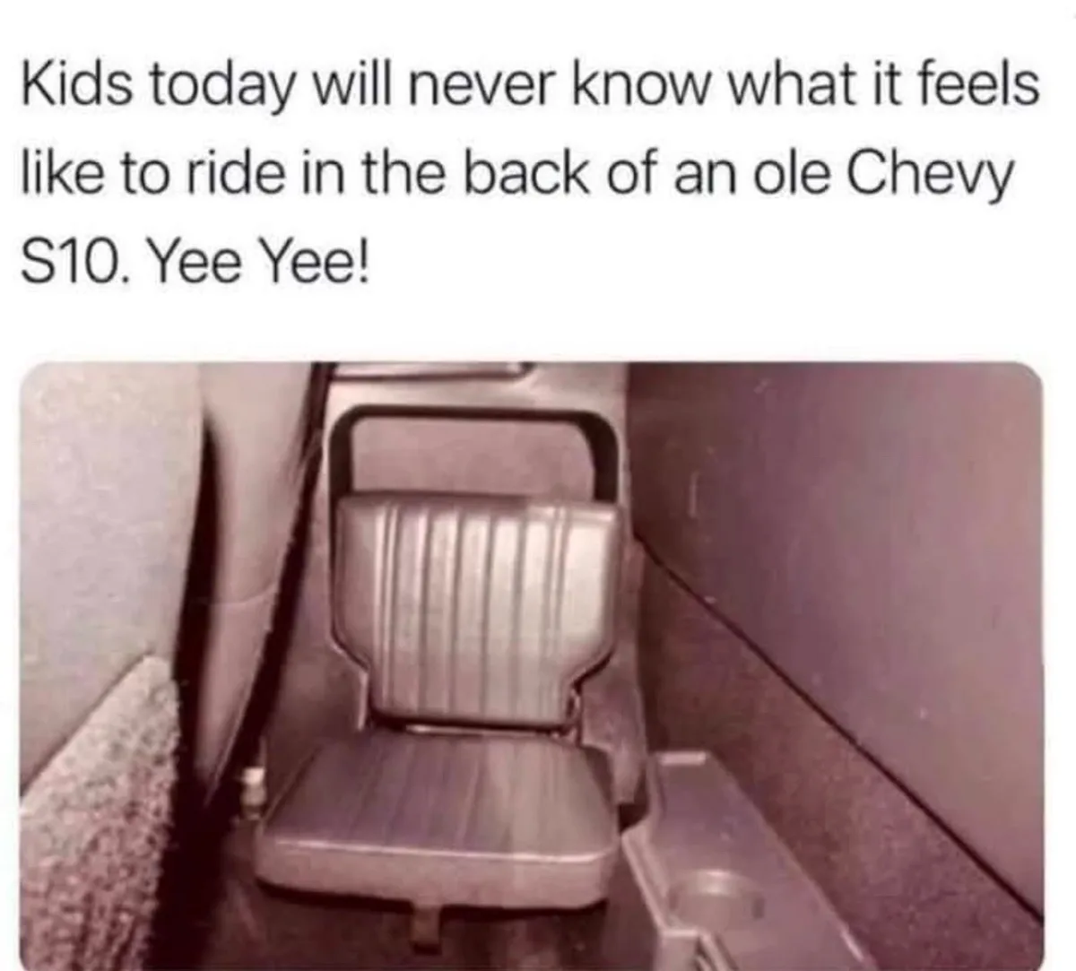 The image shows a close-up of a narrow, cramped, and dated-looking back seat inside an old Chevrolet S10 pickup truck, with…